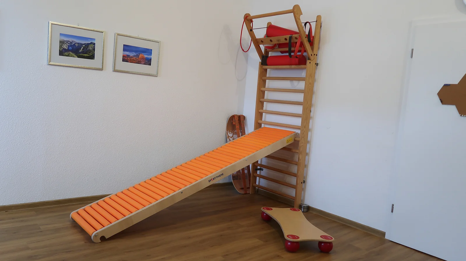 Sprossenwand mit Rollenrutsche und Rollbrett